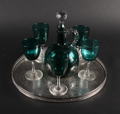 Lot 393 - A green glass drinks set with decanter, on a...