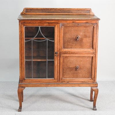 Lot 429 - A small 1920's oak lead glazed side cabinet,...