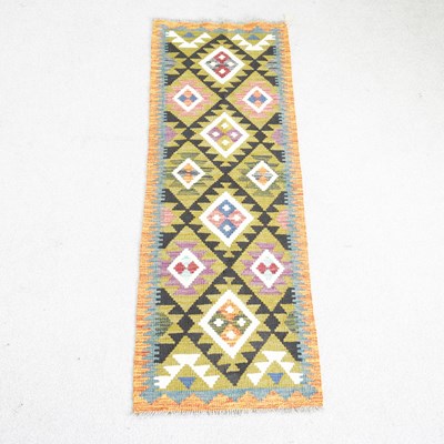 Lot 463 - A kilim runner, with rows of coloured lozenges,...