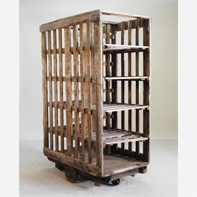 Lot 86 - An early 20th century pine rack, on metal wheels