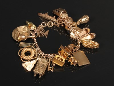 Lot 8 - A 9 carat yellow gold charm bracelet and...