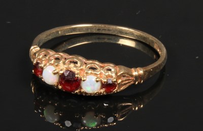 Lot 63 - A 9 carat opal and garnet dress ring, size P,...
