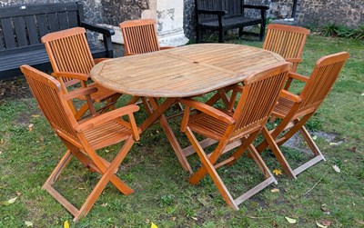 Lot 418 - A teak garden table and six chairs, with a...