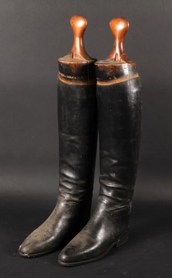 Lot 600 - A pair of black leather riding boots, on a...