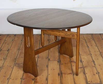 Lot 498 - An Ercol 'early dawn' elm drop-leaf dining table