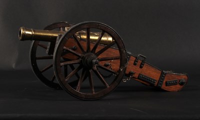 Lot 674 - A brass model Napoleonic cannon, on a wooden...