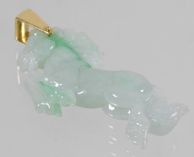 Lot 42 - A carved jade coloured hardstone horse pendant