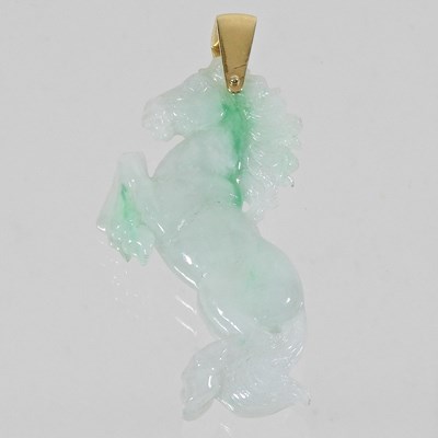 Lot 42 - A carved jade coloured hardstone horse pendant