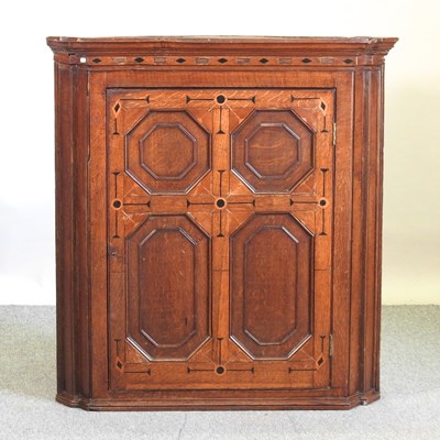 Lot 709 - A George III oak and inlaid corner cupboard