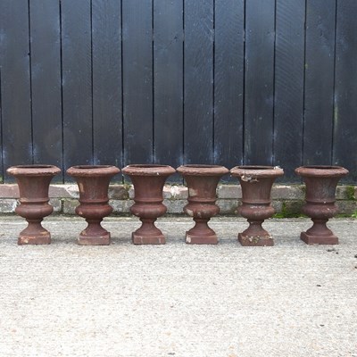 Lot 302 - A set of six small cast iron campana shaped garden urns