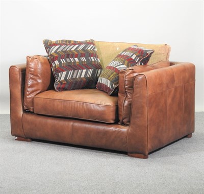 Lot 559 - A brown leather upholstered armchair