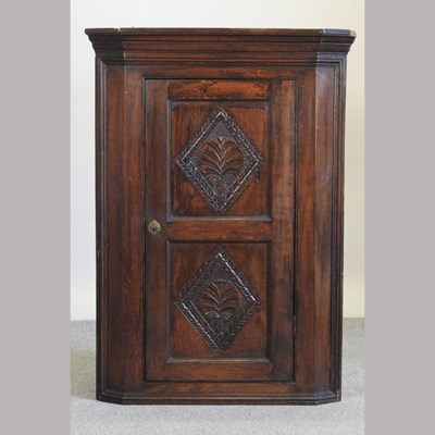 Lot 572 - A 19th century carved oak corner cupboard