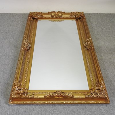 Lot 234 - An ornate modern gilt framed wall mirror