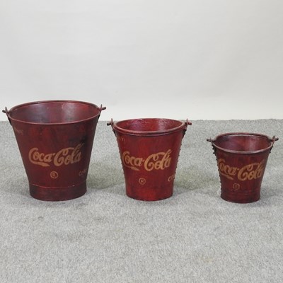 Lot 66 - A set of three painted metal Coca Cola advertising buckets