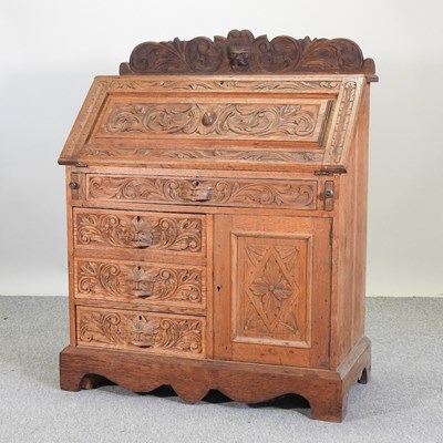 Lot 624 - An early 20th century heavily carved oak bureau