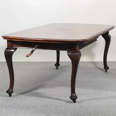 Lot 527 - An early 20th century wind-out dining table