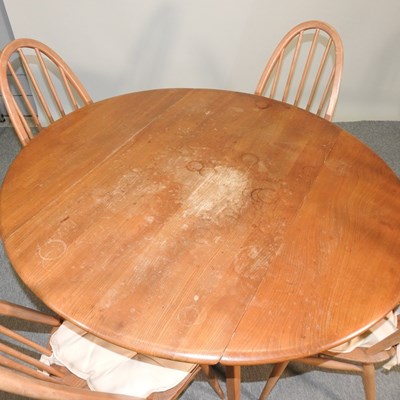 Lot 680 - An Ercol light elm dining table