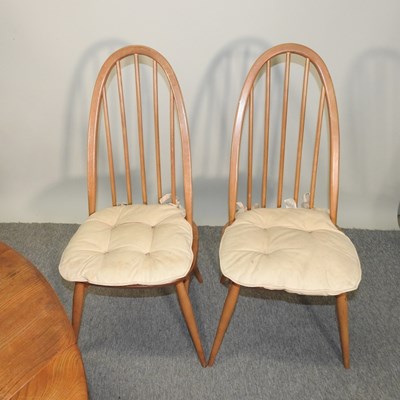 Lot 680 - An Ercol light elm dining table