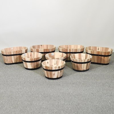 Lot 399 - A set of four coopered wooden garden planters