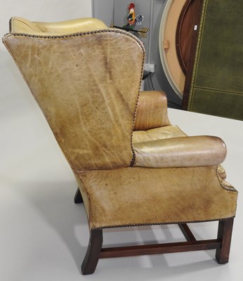Lot 28 - A Georgian style leather upholstered wing armchair
