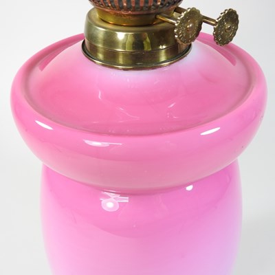 Lot 69 - A pink glass oil lamp and shade