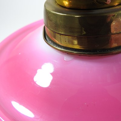 Lot 69 - A pink glass oil lamp and shade