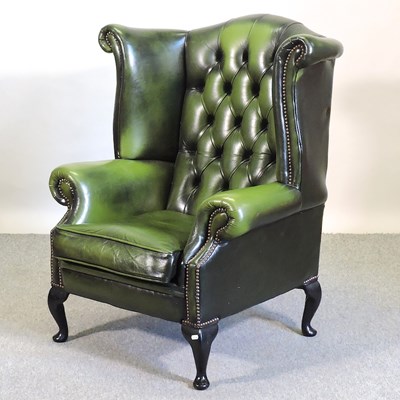 Lot 597 - A green leather upholstered armchair