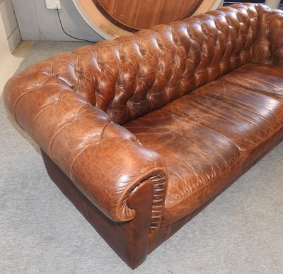 Lot 352 - A modern brown leather upholstered button back chesterfield sofa