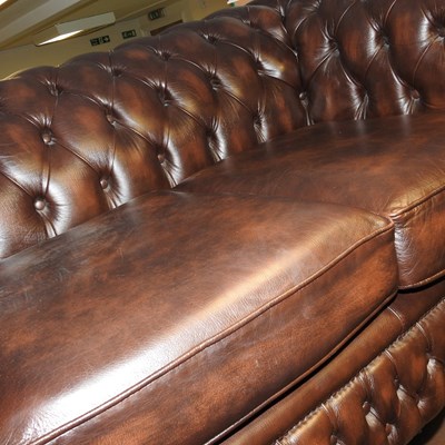 Lot 306 - A brown leather upholstered chesterfield sofa