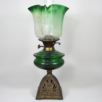 Lot 159 - A green glass and cast iron oil lamp