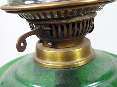 Lot 159 - A green glass and cast iron oil lamp